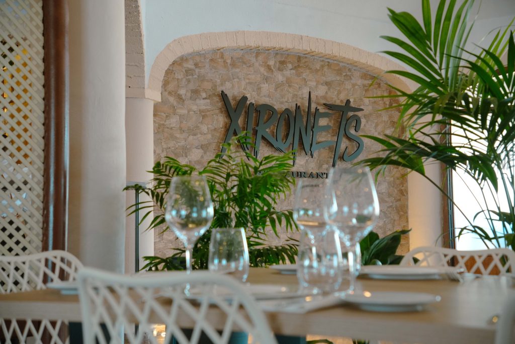 Detalle del comedor y rótulo de Xironets entre plantas y mesas